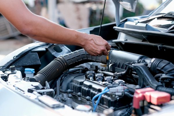 A mechanic checking the oil levels in a car engine